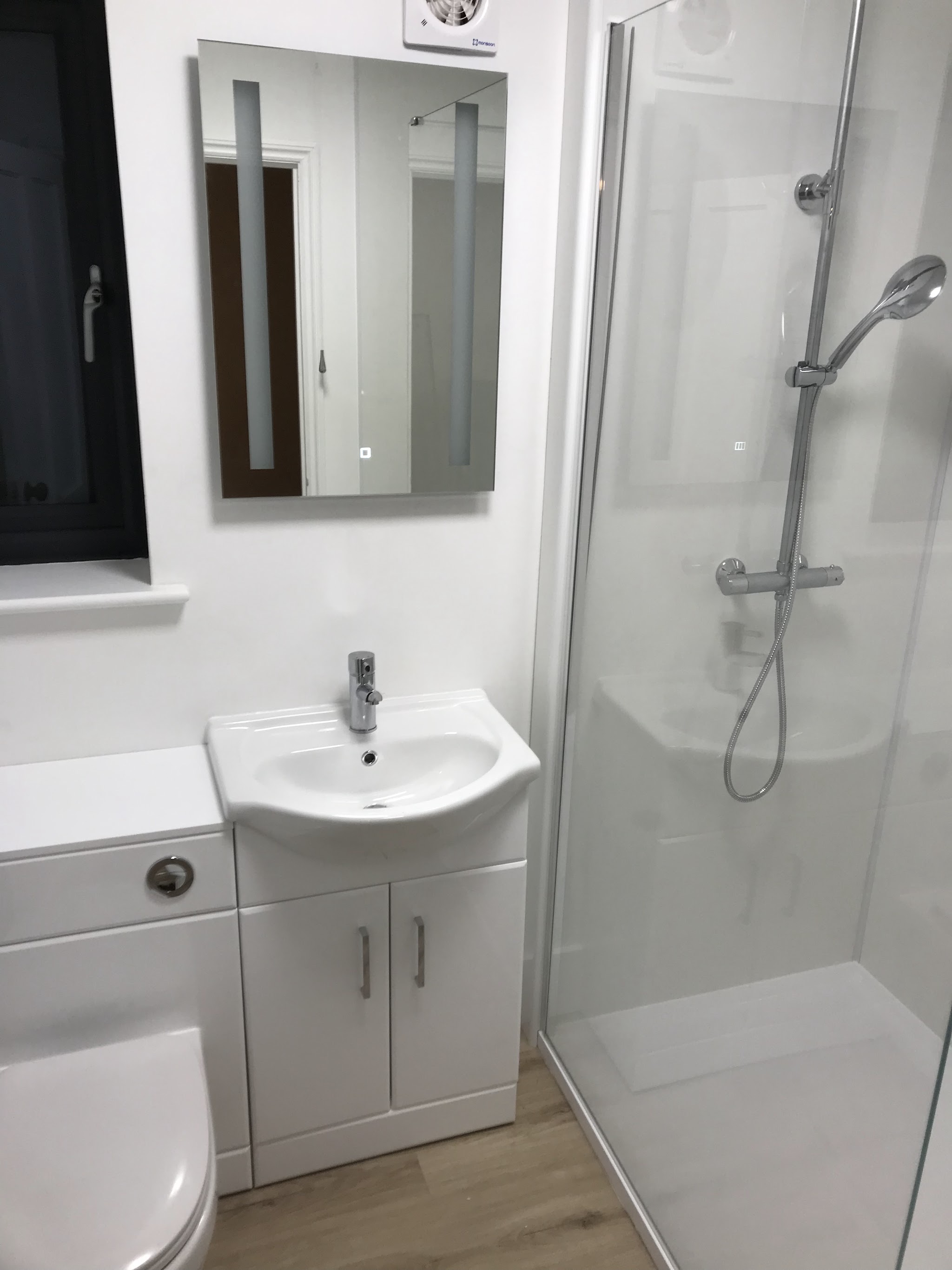 Shower room with vanity basin, LED mirror and glass shower enclosure