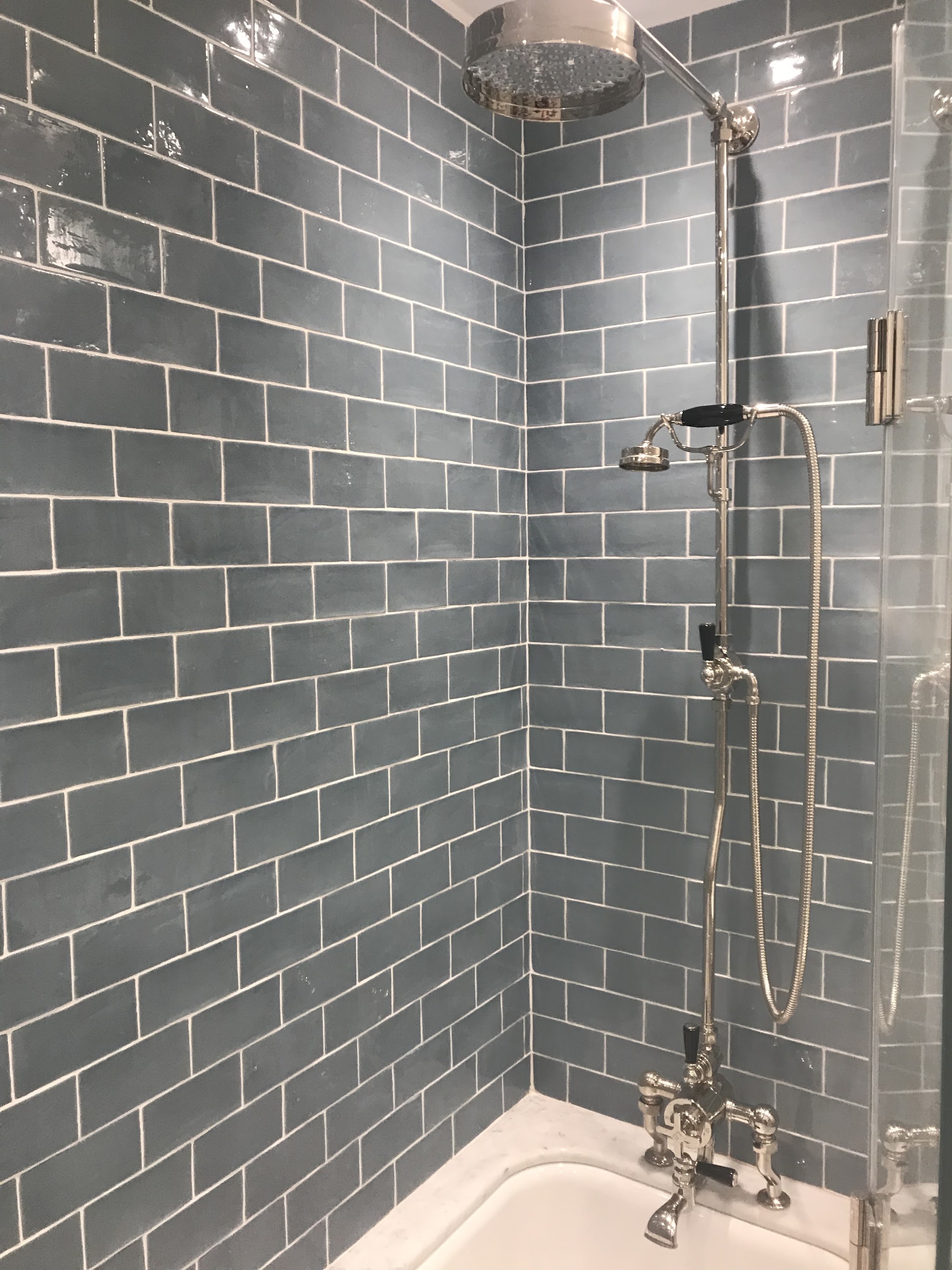 Grey-blue metro tiled bathroom with an exposed thermostatic shower and rainfall head